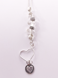 Flutter is a Crystal Essence Necklace; clear crystal stones, sterling silver beads, two sterling silver heart charms.